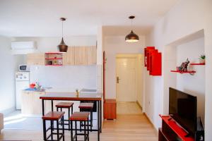 cocina con mesa y taburetes en una habitación en Peaceful City Center, en Podgorica