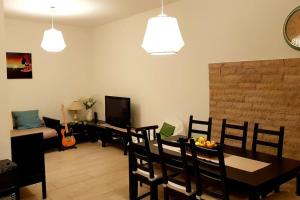 a living room with a dining room table with chairs and a television at A casa di Rudy in Biancavilla