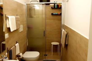 a bathroom with a toilet and a glass shower at A casa di Rudy in Biancavilla