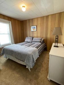 1 dormitorio con cama, lámpara y ventana en Next to Seaside Boardwalk! - Spacious 3 Bedroom, en Seaside Heights