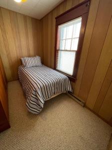 Habitación pequeña con cama y ventana en Next to Seaside Boardwalk! - Spacious 3 Bedroom, en Seaside Heights