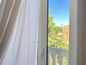 ein Fenster mit weißem Vorhang und Aussicht in der Unterkunft Alla Luce del Barocco in Lecce