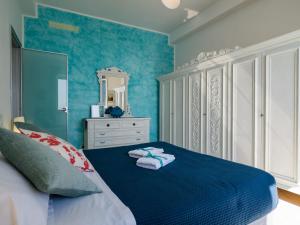 ein blaues Schlafzimmer mit einem Bett mit Handtüchern darauf in der Unterkunft Giaella Sea View Apartment in Monterosso al Mare