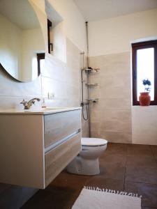 een badkamer met een wastafel, een toilet en een spiegel bij Apartamento Pirul in Haría