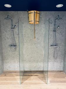 a glass shower with a bucket hanging from a ceiling at Apartament Błękitna Zatoka z Sauną in Puck