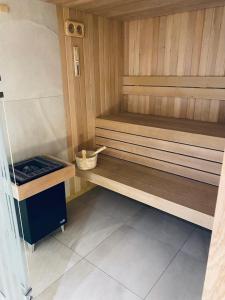 a small sauna with a wooden bench in a room at Apartament Błękitna Zatoka z Sauną in Puck