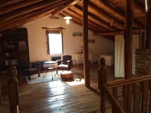 sala de estar con suelo de madera y ventana grande en Casa Los Aperos, en Santibáñez de Valcorba
