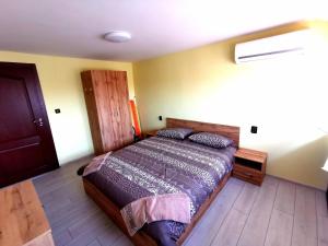 a bedroom with a bed and a wooden floor at Balkan view apartment in Vratsa