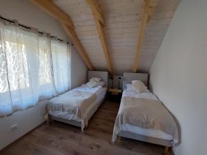 Habitación en el ático con 2 camas y ventana en Apartamenty Ptasi Przylądek, en Mrągowo