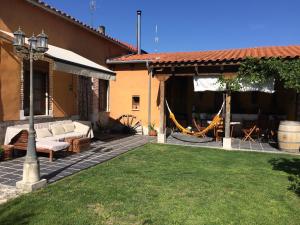 Santibáñez de Valcorba的住宿－Casa Los Aperos，房屋设有1个带沙发和秋千的庭院