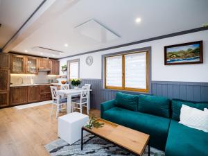 a living room with a green couch and a table at ALM SKI Jaworki in Jaworki