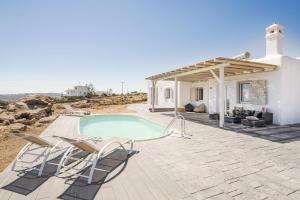 Villa con piscina y patio con sillas. en Ocean view villa, en Mykonos ciudad