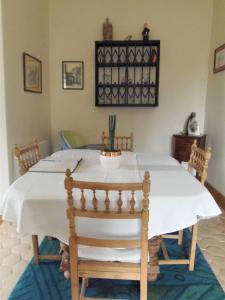 een eetkamer met een witte tafel en stoelen bij Les Cimaises du Couvent in Beaune