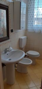 a bathroom with a sink and a toilet and a window at Via Pioppa 24 in Ferrara +10 photos