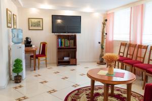 a living room with a tv and a table at Hotel Runmis in Vilnius