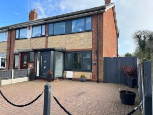 a brick house with a chain attached to it at The Brook House - Spacious 3 Bed Home From Home in Burton in Burton upon Trent