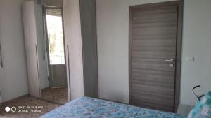 フランカヴィッラ・アル・マーレにあるTra cielo e mareのベッドルーム1室(鏡、ベッド1台、ドア付)