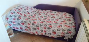 ein Bett mit einer Decke darüber in der Unterkunft Via Pioppa 24 in Ferrara