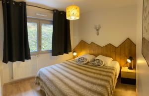 a bedroom with a bed with a wooden headboard at La Tintaine- T2 avec Terrasse in Villard-de-Lans