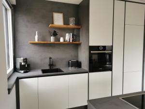a kitchen with white cabinets and a sink and a microwave at Am Grimming 14 in Tauplitz