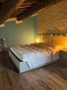 Castel RitaldiにあるLocanda Roviccianoのレンガの壁の客室で、大型ベッド1台を利用できます。