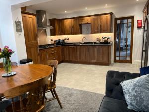 a kitchen with wooden cabinets and a wooden table at The Brook House - Spacious 3 Bed Home From Home in Burton in Burton upon Trent