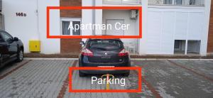a car parked in a parking lot in front of a building at Apartman Cer in Banja Koviljača