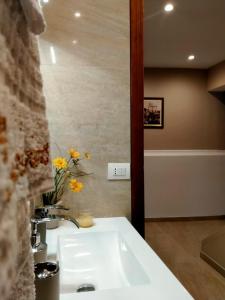 a white sink in a bathroom with yellow flowers at Casa vacanza Il Mandarino in Viagrande +22 photos