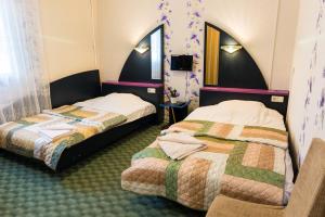 a hotel room with two beds and a mirror at Hotel Runmis in Vilnius