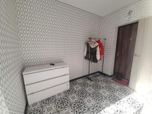 a bedroom with a white dresser and a wall at Лузановка in Odesa