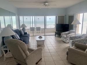 a living room with a couch and chairs and a television at Island House Beach Resort 5S in Siesta Key