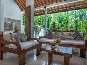 a living room with two chairs and a table at Medori Villa Seminyak in Seminyak