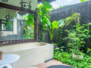a bathtub in a bathroom with plants at Villa Medori - Private Pool Seminyak in Seminyak +5 photos
