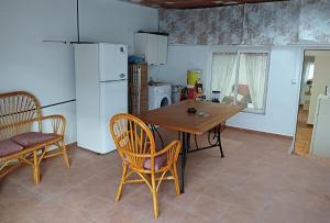 a kitchen with a table and chairs and a refrigerator at Apartamento Casa Quiles in Losa del Obispo