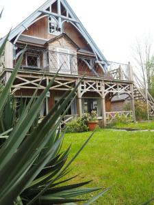 una casa antigua con techo de metal y césped verde en Chambres d'Hôtes Fleur de Sel en Roz-sur-Couesnon