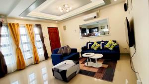 ein Wohnzimmer mit einem blauen Sofa und einem Tisch in der Unterkunft KASSFFER APARTMENT in Panglao