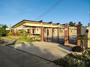 a house with a fence in front of a driveway at KASSFFER APARTMENT in Panglao