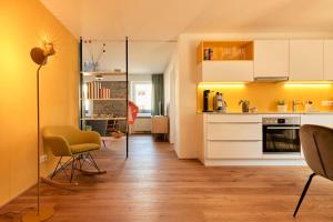 uma cozinha com paredes amarelas e pisos em madeira em Rotes Haus Bregenz Pop-Up Wohnung em Bregenz