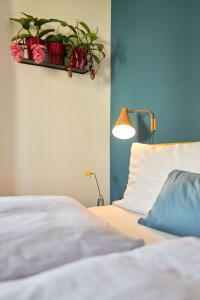 a bedroom with a bed with potted plants on a shelf at Rotes Haus Bregenz Pop-Up Wohnung in Bregenz