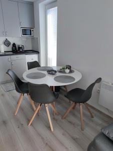 a kitchen with a table and chairs in a room at Apartmány Meghan in Podhájska
