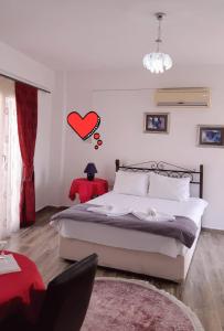 a bedroom with a bed and a red heart on the wall at Malia Holiday Let in Famagusta