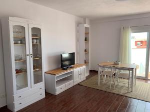 a living room with a table and a television at Vivienda vacacional La Plaza in Santa Úrsula