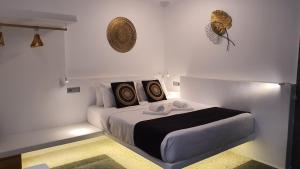 Mykonos Double Luxury Mini Suites - Adults only في أنو ميرا: غرفة نوم بيضاء مع سرير مع وسادتين
