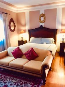 1 dormitorio con 1 cama con sofá y espejo en Casa Arequipa, en Arequipa