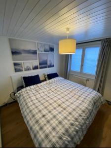 ein Schlafzimmer mit einem Bett mit einer karierten Decke in der Unterkunft 2 pièces équipé avec parking privé in Gryon