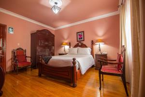 a bedroom with a large bed and two chairs at Casa Arequipa in Arequipa