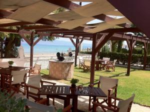 patio ze stołem i krzesłami oraz plażą w obiekcie Chris Studios & Apartments w mieście Lechaio