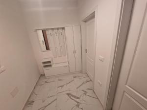 baño con suelo de mármol y espejo en Atena Apartment, en Ohrid