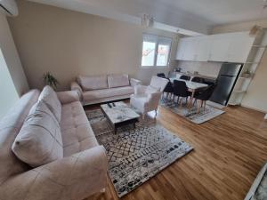 a living room with a couch and a kitchen at Atena Apartment in Ohrid +2 photos