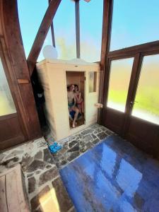Torniella的住宿－Podere I Casaloni - La casa nel bosco，两人坐在带窗户的房间里,坐在桑拿浴室